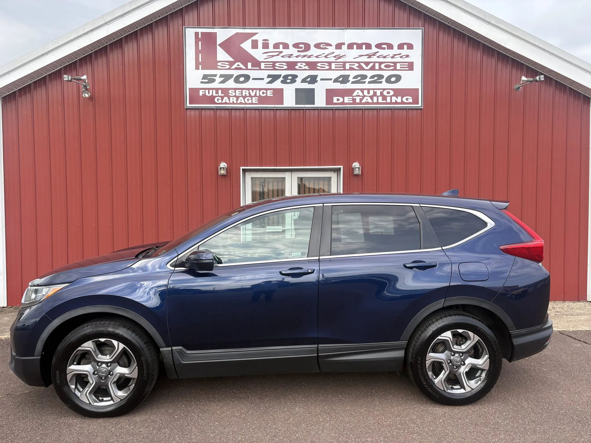 A dark blue 2019 Honda CR-V EX parked in front of the Klingerman Family Auto building
